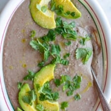 All you need is a few simple ingredients and time for the beans to get tender for restaurant-style refried beans cooked right on the stovetop. A healthy, vegan refried bean recipe! #refriedbeans #veganrefriedbeans #beanrecipe #mexicanrecipe
