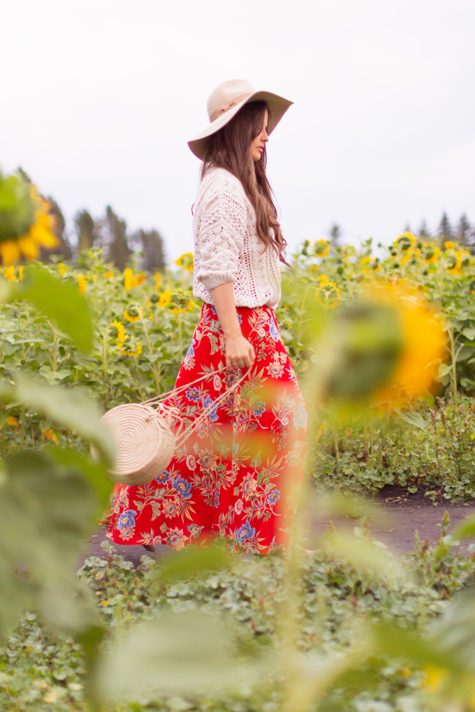 LATE SUMMER 2019 LOOKBOOK | Crimson and Clover: How to Style Maxi Dresses for Summer / Autumn | Red Maxi Dress Outfit Ideas | Bohemians Transitional Outfit Ideas | Brunette woman wearing a floral printed red maxi dress with a fishermanβs knit sweater, floppy felt tan hat and a woven round bag in a sunflower field | Canadian sunflower field in Alberta at Sunset | Bowden Sunmaze Review | Calgary, Alberta, Canada Lifestyle and Fashion Blogger, Justine Celina Maguire | JustineCelina.com