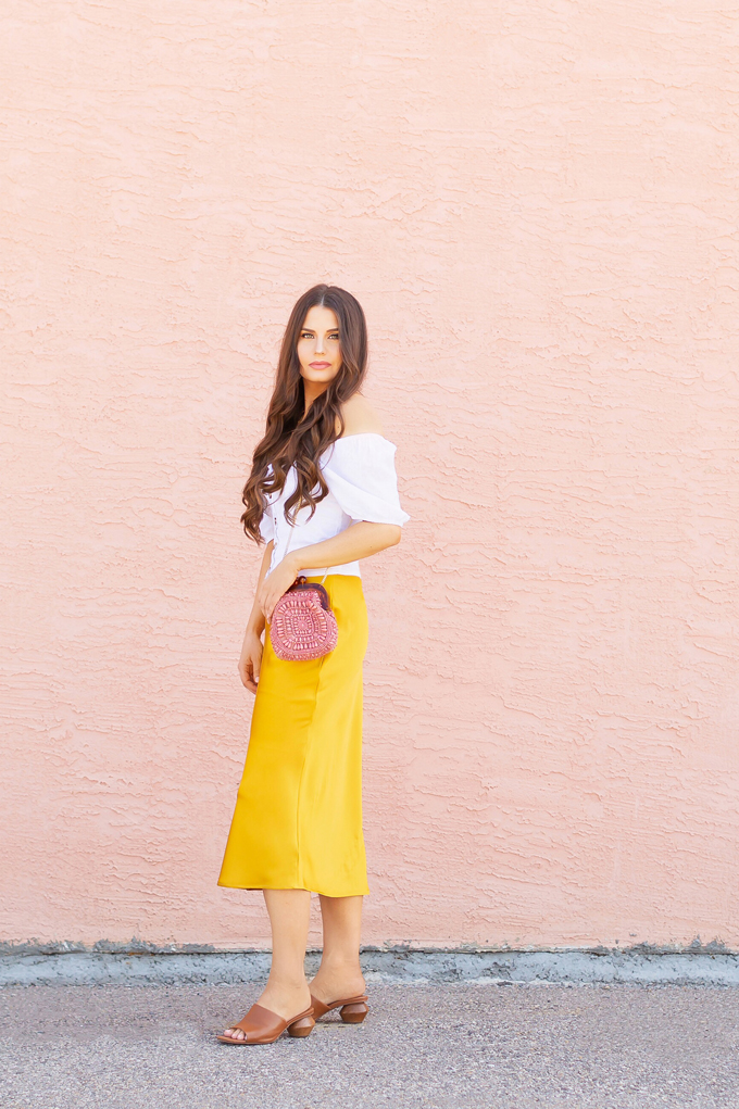LATE SUMMER 2019 LOOKBOOK | Walking on Sunshinet: How to Style TopShopβs Bias Cut Satin Midi Skirt for Summer / Autumn | TopShop Yellow Satin Skirt Outfit Ideas | Casual Daytime Transitionl Outfit Ideas | Brunette woman wearing a Topshop Yellow Satin Midi Skirt styled with a white button-down Bardot top, brown leather mules with a wooden heel and a Pantone Living Coral beaded bag | Summer 2019 Trends | Calgary Fashion & Creative Lifestyle Blogger // JustineCelina.com