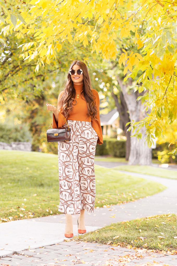 Summer to Fall 2019 Transitional Lookbook : 60βs Sophisticate | Top Summer to Fall 2019 Transitional Trends | Top Autumn 2019 Trends and How to Wear Them | H&M x Richard Allen Collection Review | Fall 2019 Professional Outfit Ideas | Brunette woman wearing H&M x Richard Allen Wide Leg Pants, Pantone Dark Cheddar Bell Sleeve Mockneck, Chocolate Brown Croc Embossed Bag and Zara Burnt Orange and Navy DβOrsay Pumps | Top Calgary Fashion & Creative Lifestyle Blogger // JustineCelina.com