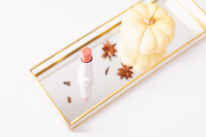 My Top 5 Pumpkin Spice Lipsticks | JustineCelinaβs favourite fall lipsticks | The Best Pumpkin Spice Lipsticks for Fall | Fall 2020 Lipstick Trends | Physicians Formula Organic Wear Tinted Lip Treatment in Gingersnap Photos, Review, Swatches | Light / Medium Skintone | The Best Drugstore Fall Lipsticks | The Best Pumpkin Spice Lipsticks for Fall | Lipstick on a Mirrored Tray with spices, a white mini pumpkin and pampas grass in the background | Calgary Beauty Blogger // JustineCelina.com