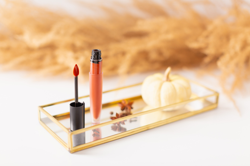 My Top 5 Pumpkin Spice Lipsticks | JustineCelinaβs favourite fall lipsticks | The Best Pumpkin Spice Lipsticks for Fall | Fall 2020 Lipstick Trends | L'Oreal Rouge Signature Liquid Lip Colour in I Amaze Photos, Review, Swatches | Light / Medium Skintone | The Best Drugstore Fall Lipsticks | The Best Pumpkin Spice Lipsticks for Fall | Lipstick on a Mirrored Tray with spices, a white mini pumpkin and pampas grass in the background | Calgary Beauty Blogger // JustineCelina.com