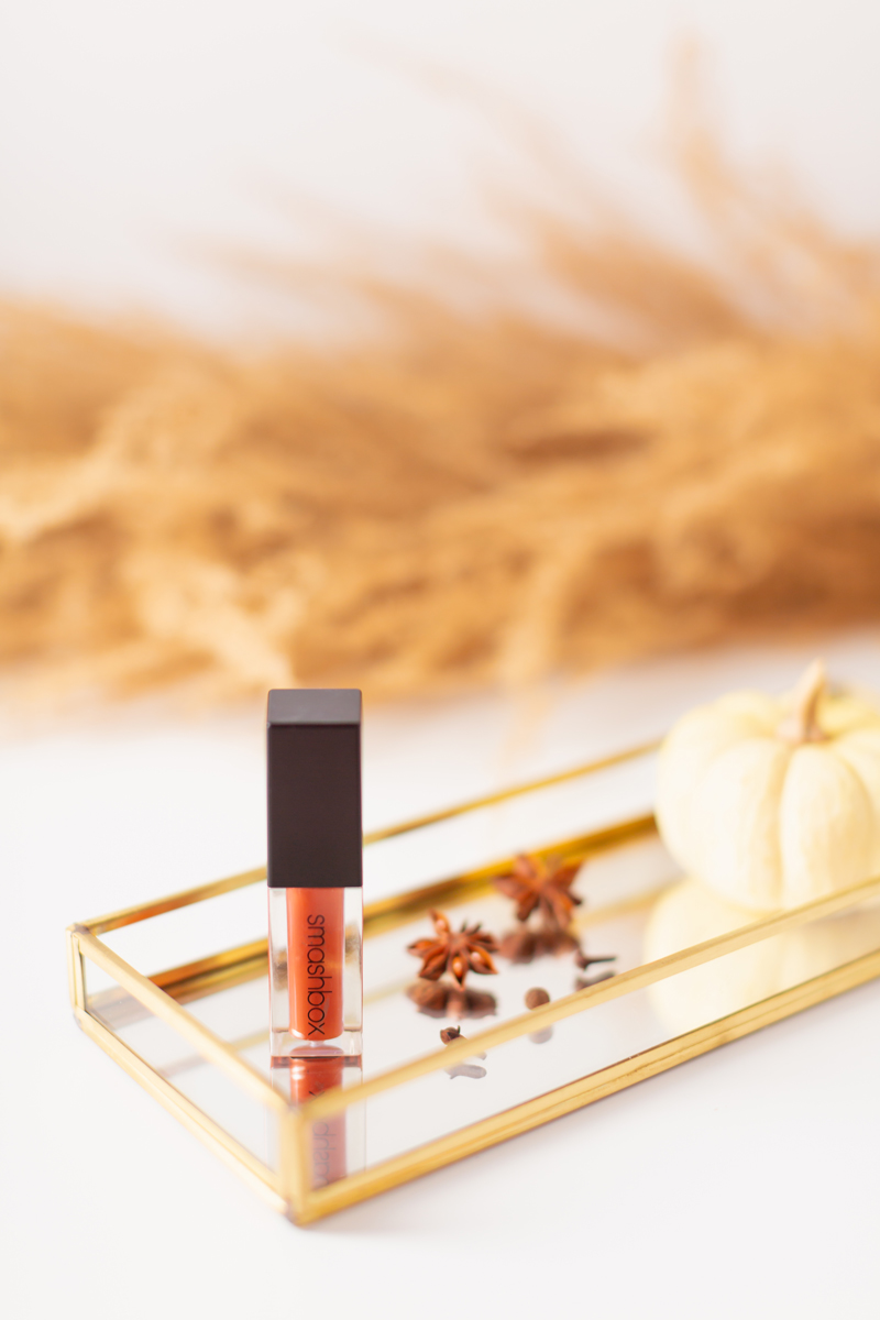 My Top 5 Pumpkin Spice Lipsticks | JustineCelinaβs favourite fall lipsticks | The Best Pumpkin Spice Lipsticks for Fall | Fall 2020 Lipstick Trends | Smashbox Always On Matte Liquid Lipstick in Out Loud Photos Review Swatches and Du[es | Light / Medium Skintone | The Best Drugstore Fall Lipsticks | The Best Pumpkin Spice Lipsticks for Fall | Lipstick on a Mirrored Tray with spices, a white mini pumpkin and pampas grass in the background | Calgary Beauty Blogger // JustineCelina.com