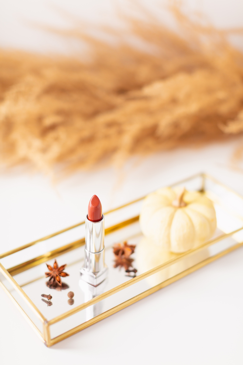 My Top 5 Pumpkin Spice Lipsticks | JustineCelinaβs favourite fall lipsticks | The Best Pumpkin Spice Lipsticks for Fall | Fall 2020 Lipstick Trends | LancΓ΄me Matte Shaker High Pigment Liquid Lipstick in Abrick Adabra Photos, Review, Swatches | Light / Medium Skintone | The Best Drugstore Fall Lipsticks | The Best Pumpkin Spice Lipsticks for Fall | Lipstick on a Mirrored Tray with spices, a white mini pumpkin and pampas grass in the background | Calgary Beauty Blogger // JustineCelina.com