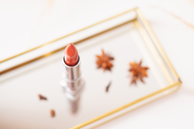 My Top 5 Pumpkin Spice Lipsticks | JustineCelinaβs favourite fall lipsticks | The Best Pumpkin Spice Lipsticks for Fall | Fall 2020 Lipstick Trends | LancΓ΄me Matte Shaker High Pigment Liquid Lipstick in Abrick Adabra Photos, Review, Swatches | Light / Medium Skintone | The Best Drugstore Fall Lipsticks | The Best Pumpkin Spice Lipsticks for Fall | Lipstick on a Mirrored Tray with spices, a white mini pumpkin and pampas grass in the background | Calgary Beauty Blogger // JustineCelina.com