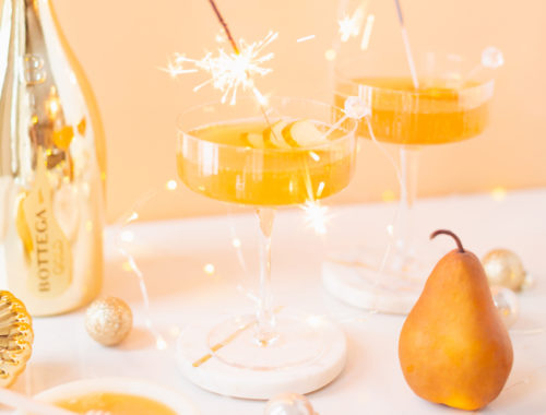 Gilded Vanilla Pear Sparkler | A glitzy, French 75 inspired New Years Eve cocktailΒ featuring 24 karat gold infused gin, Brut Prosecco, Italian vanilla liqueur, lemon juice andΒ Honeyed Vanilla Pear Syrup | Best NYE 2020 cocktails | How to Make sparkling NYE cocktails at home | Champagne cocktail recipe | Champagne Christmas drinks | New Years Eve Sparklers | Modern Refined Sugar Free French 75 | NYE Cocktail Party Recipes | Calgary Creative Lifestyle & Cocktail Blogger // JustineCelina.com