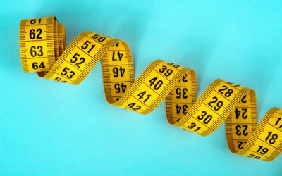 blue backgrond with a coiled yellow metric tape measure