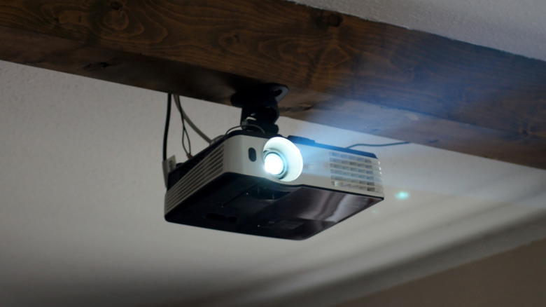 A home projector installed on the ceiling