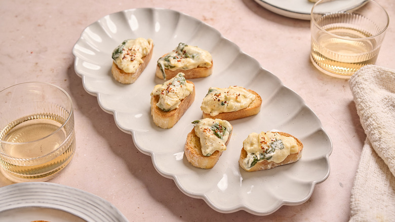 spinach and artichoke dip crostinis on a platter