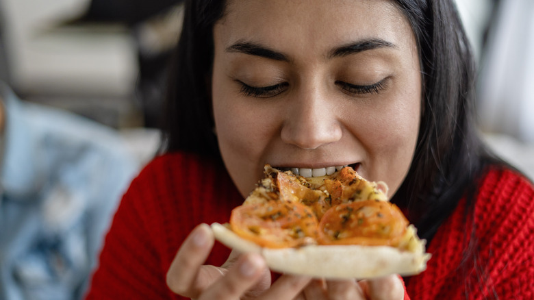 woman eating a slice of pizza