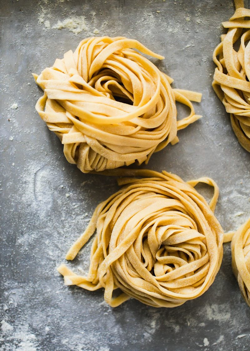 Homemade pasta (coiled nests) on a sheet pan.