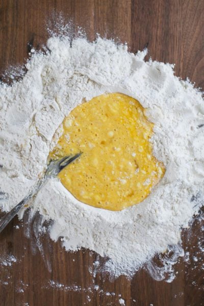 Mixed eggs in a flour well for homemade pasta.