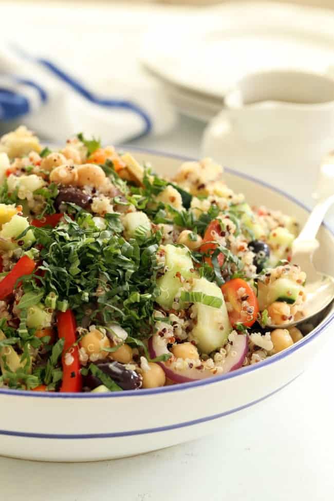 mediterranean quinoa salad A large white bowl filled with a cold quinoa salad.