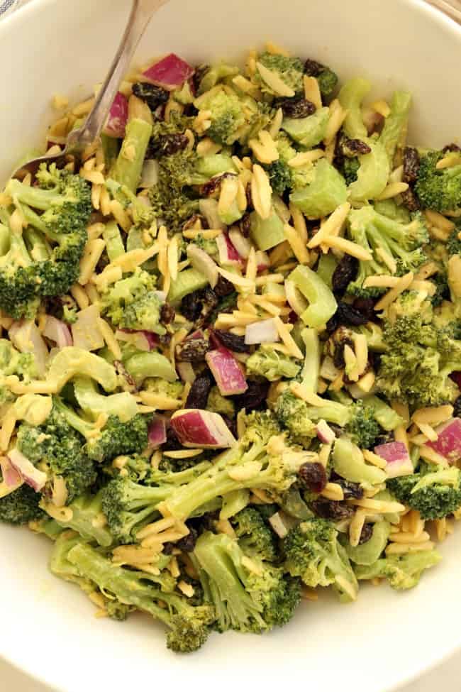 easy broccoli salad A white bowl of chopped broccoli raisin salad.