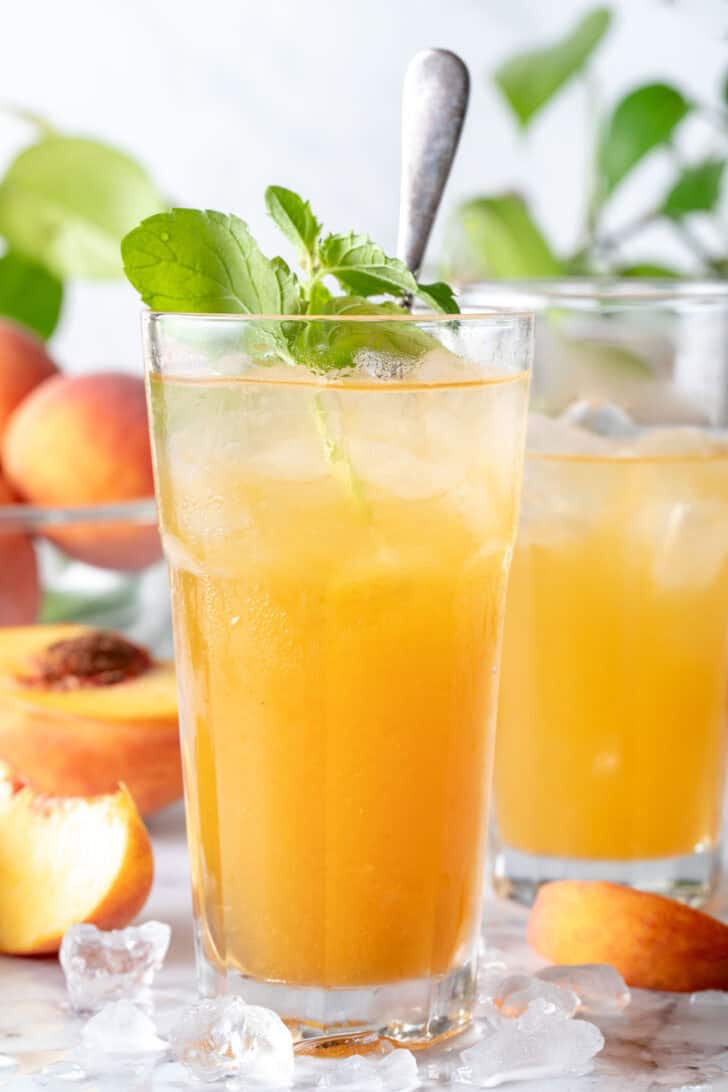 Peach Iced Tea Two clear dinking glasses filled with peach iced tea.