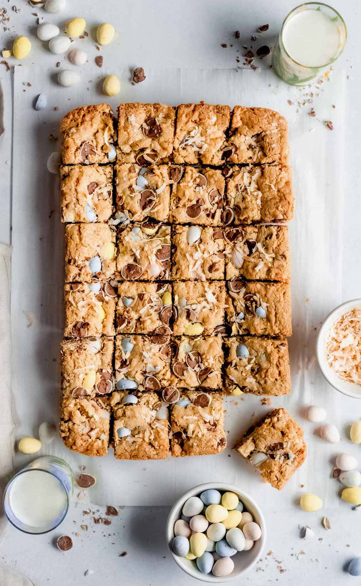 Cadbury blondies cut into squares with Cadbury mini eggs, coconut, and chocolate chips.